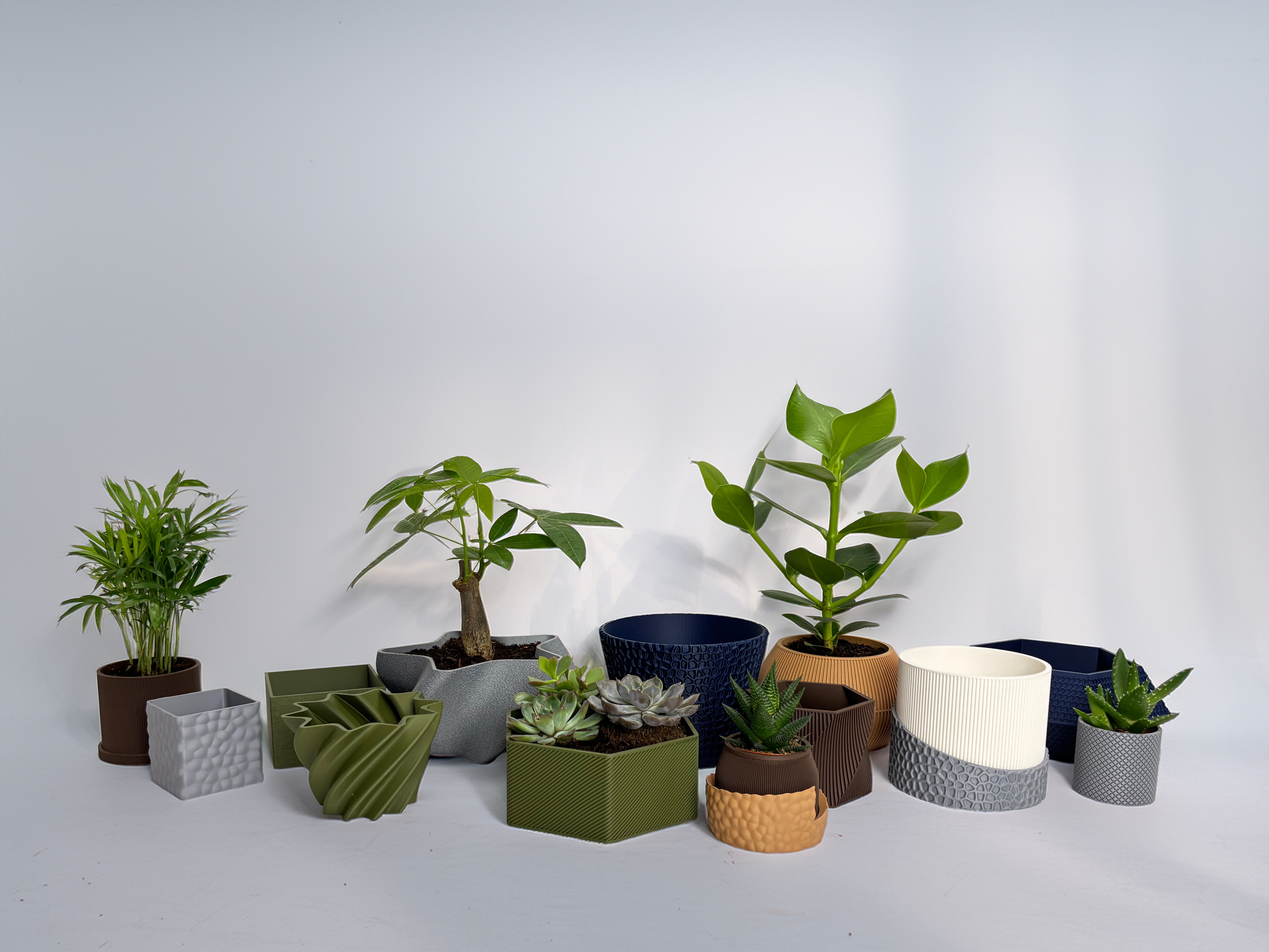Collection of 3D-printed pots and planters in various shapes, textures, and colors